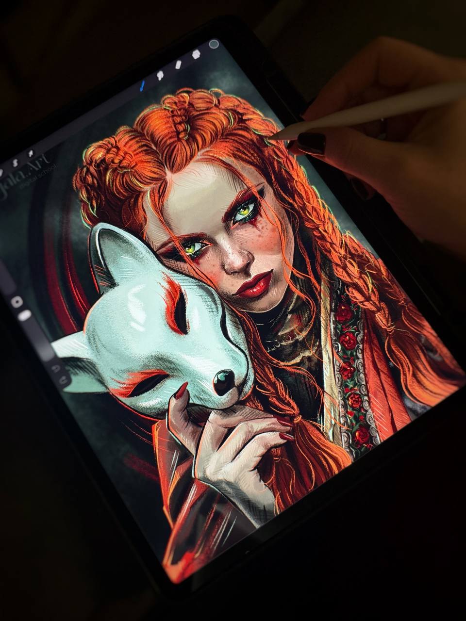 Готовый цифровой портрет на экране iPad в Procreate: рыжая девушка с косами и веснушками прижимает к щеке белую маску лисы, рука со стилусом дорисовывает пряди